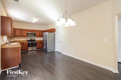 A kitchen with wooden cabinets and a grey refrigerator.