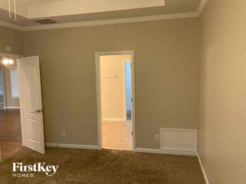 an empty living room with a door to a hallway
