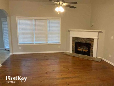 a living room with a fireplace and a ceiling fan