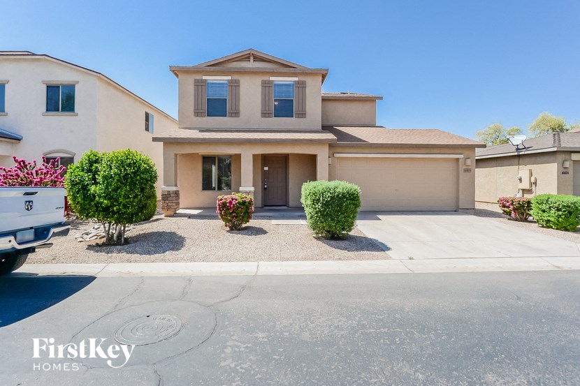 a beige house with a driveway and a garage door
