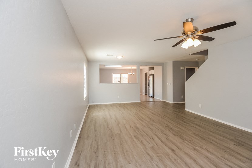 a living room with white walls and a ceiling fan