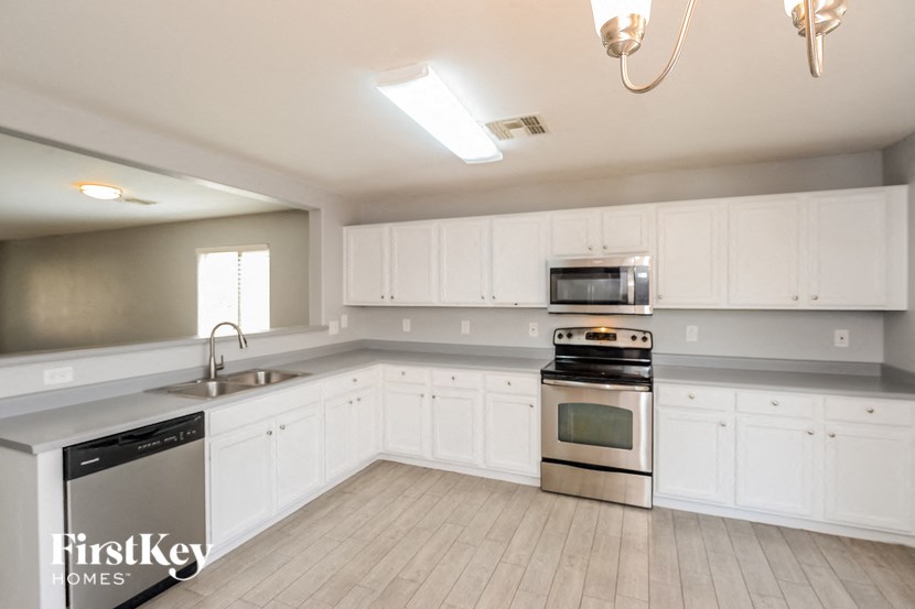 a kitchen with white cabinets and stainless steel appliances