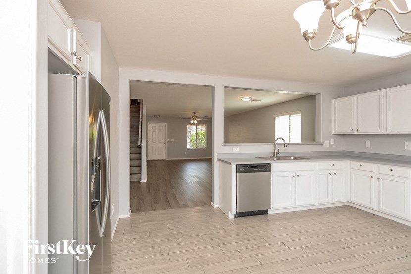 a kitchen with white cabinets and a stainless steel refrigerator