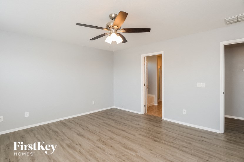 the living room of an empty house with a ceiling fan