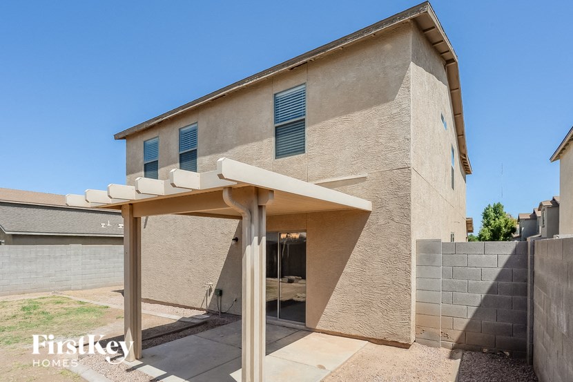 a brick house with a covered porch and a stone wall