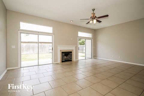 A spacious room with a fireplace and sliding glass doors.