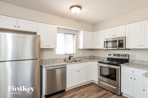 a kitchen with white cabinets and stainless steel appliances