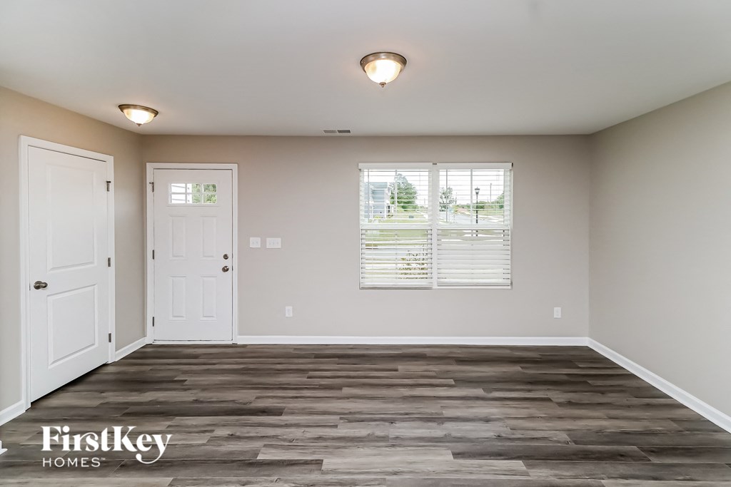 A room with wooden flooring and two white doors.