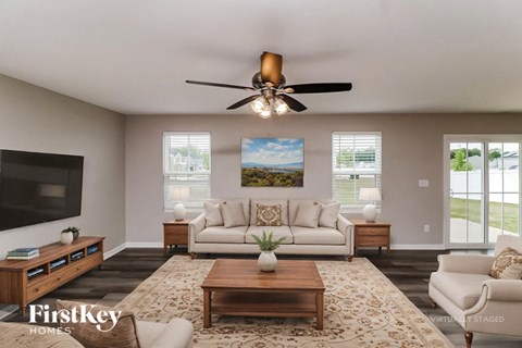A living room with a television, a couch, a coffee table, and a painting on the wall.