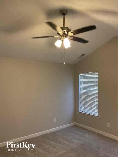 an empty room with a ceiling fan and a window