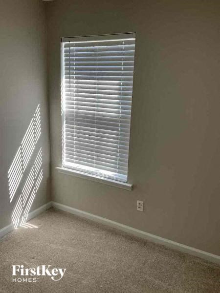 an empty room with a window with blinds