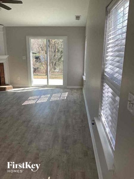 a empty living room with a window and a wood floor
