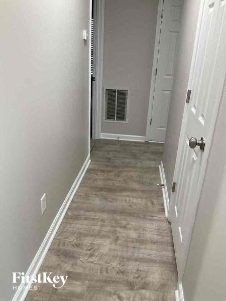 a hallway with white walls and a white door