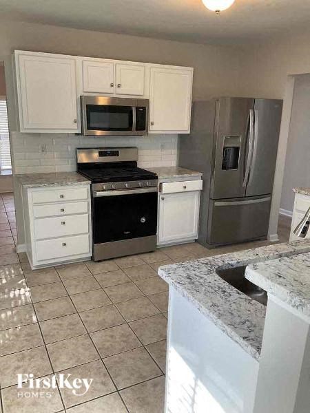 a kitchen with stainless steel appliances and white cabinets
