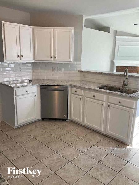 a kitchen with white cabinets and a stainless steel sink