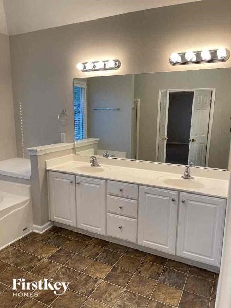 a white bathroom with two sinks and a mirror