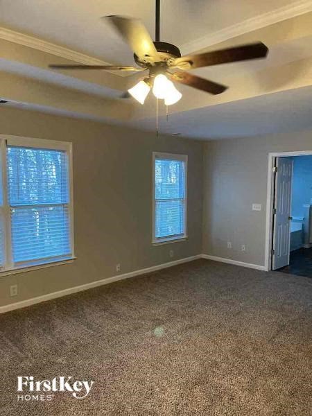 an empty room with a ceiling fan and a door