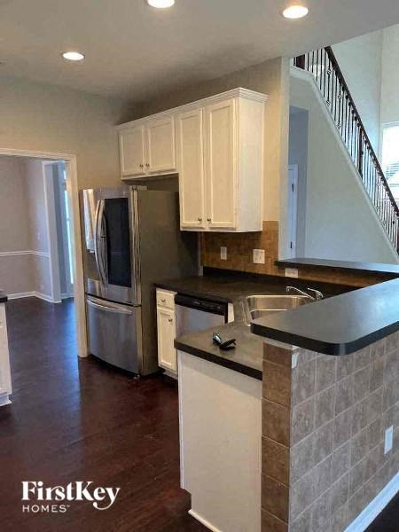 a kitchen with a stainless steel refrigerator and a sink
