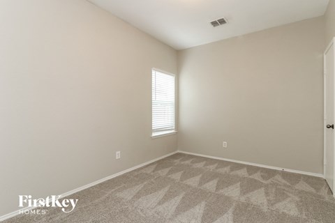 the living room of a home with carpet and a window
