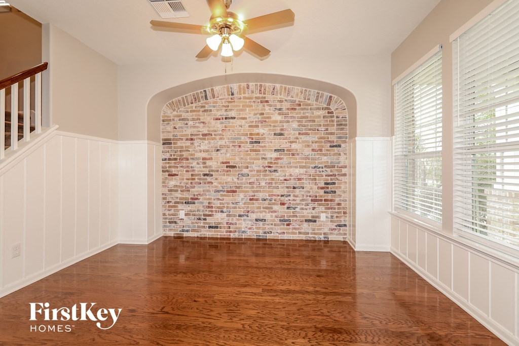 A room with a brick wall and wooden floors.