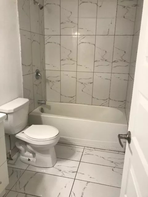 a bathroom with a toilet and a bath tub