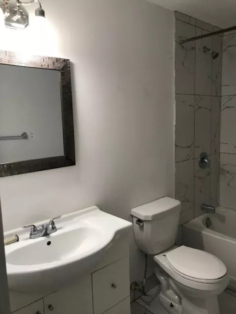 a bathroom with a toilet and a sink and a mirror
