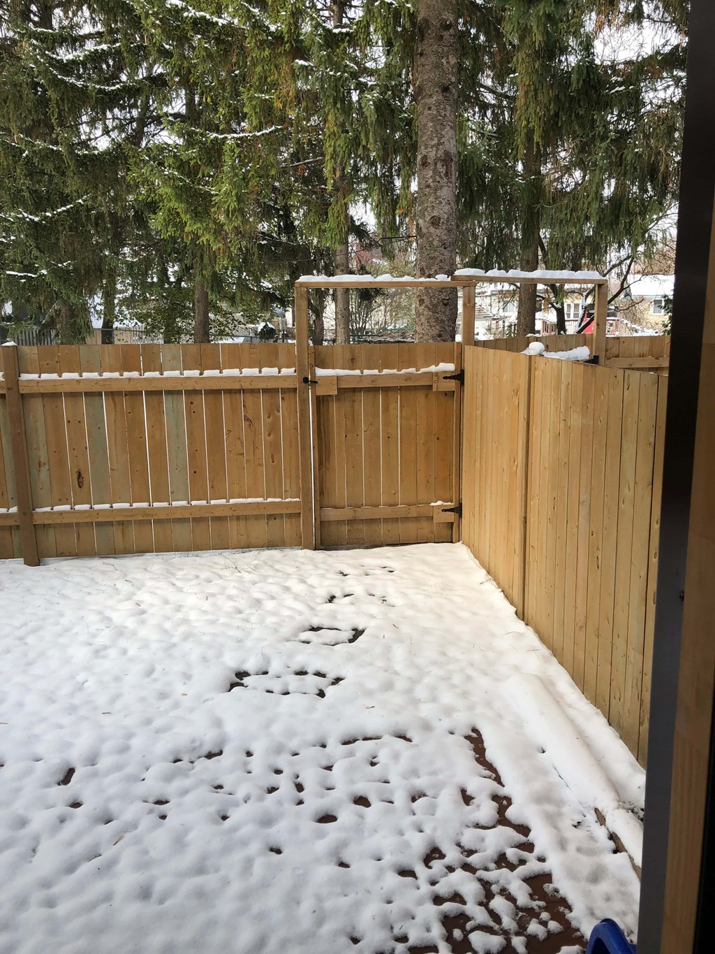 a wooden fence with snow on the ground