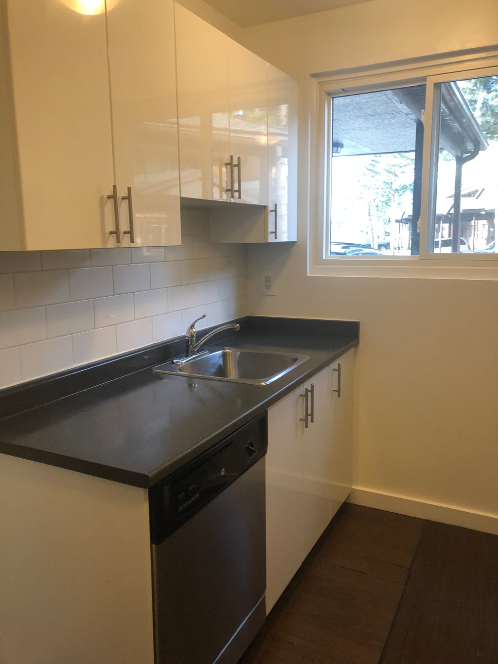 an empty kitchen with a sink and a window