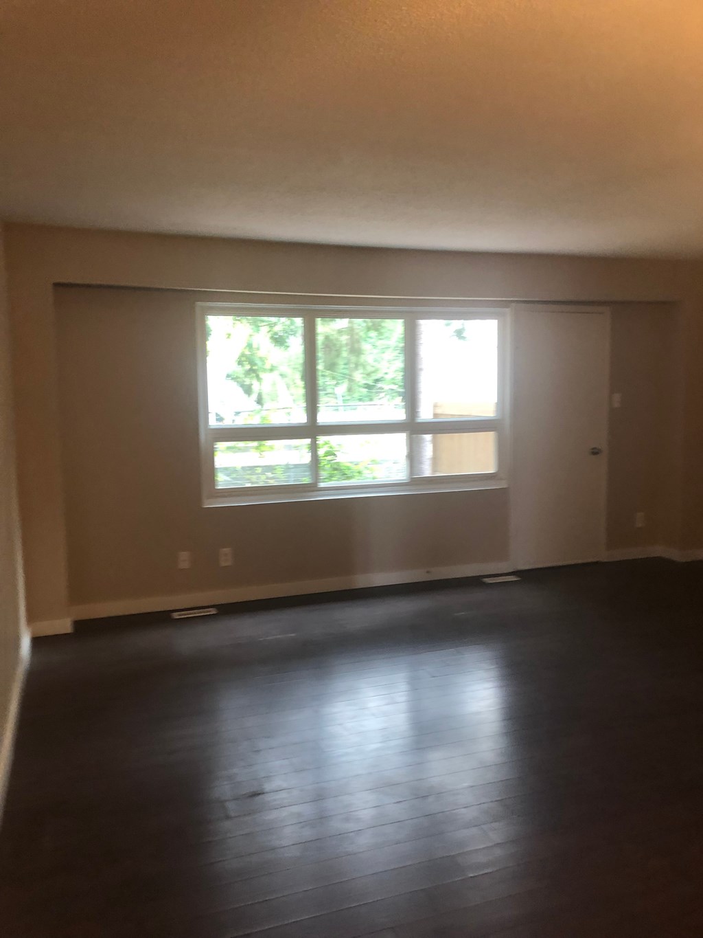 an empty living room with a large window