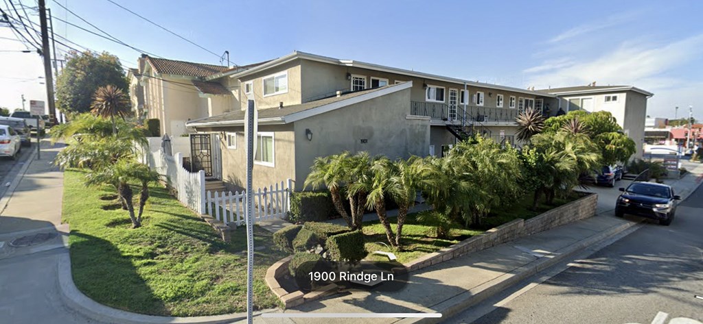 A street view of a residential area with houses and parked cars.