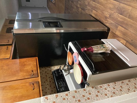 A black oven with a glass door is in a kitchen with wooden cabinets.