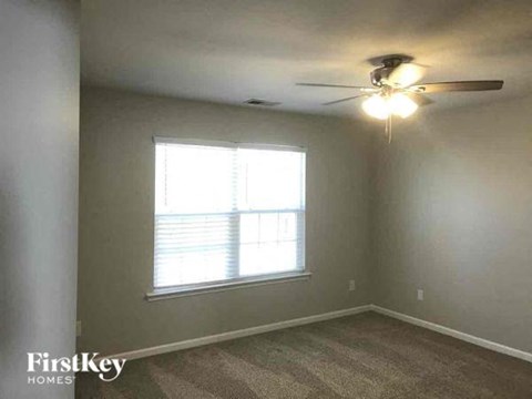 a bedroom with a ceiling fan and a window