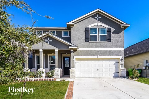 A house with a garage and a driveway in front of it.