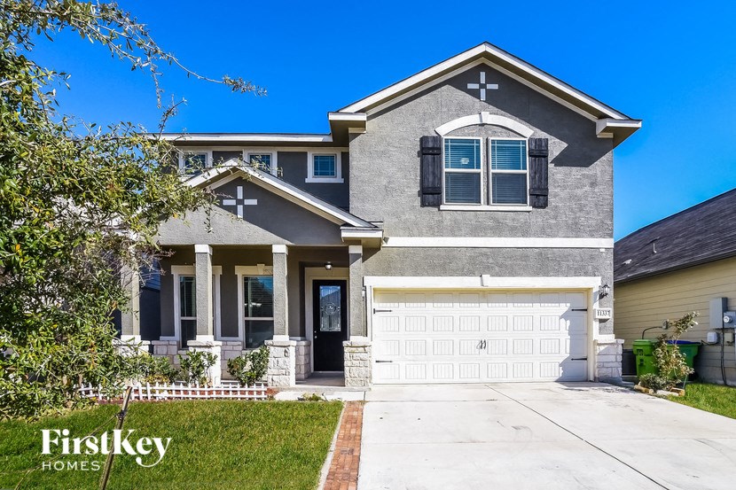 A house with a garage and a driveway in front of it.