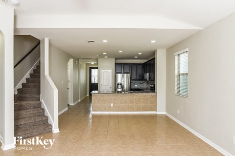 A spacious living room with a staircase on the left side.