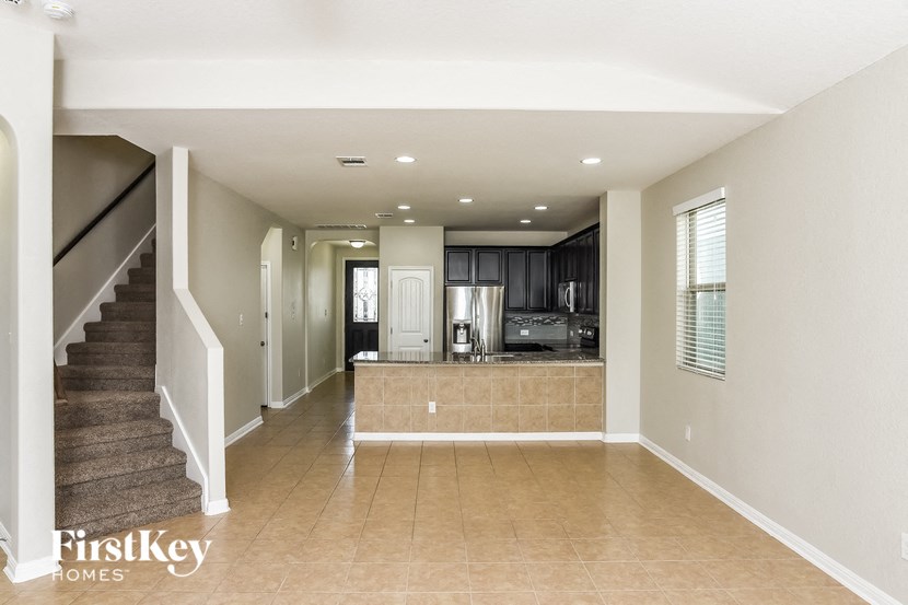A spacious living room with a staircase on the left side.