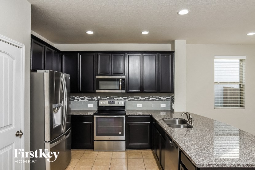 A kitchen with black cabinets and stainless steel appliances.