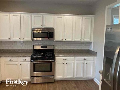 a kitchen with stainless steel appliances and white cabinets