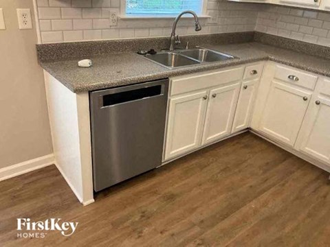 a kitchen with white cabinets and a sink