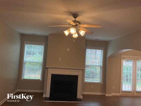 a living room with a ceiling fan and a fireplace