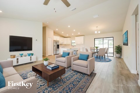 A living room with a blue rug and a wooden coffee table.