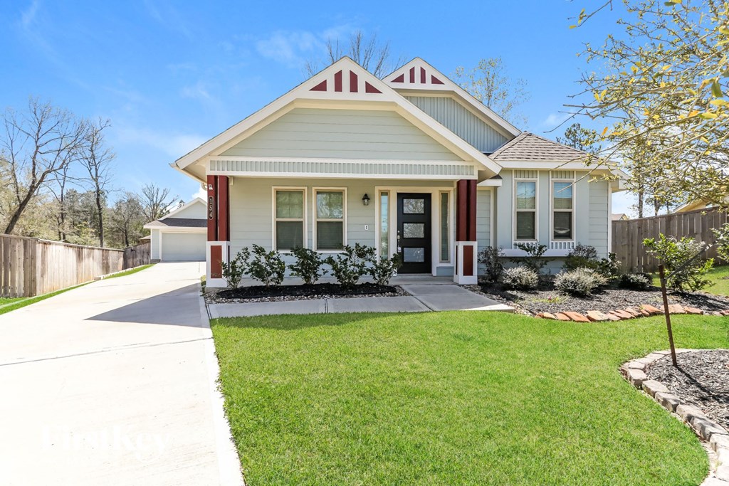 a white house with red trim and a sidewalk in front of it