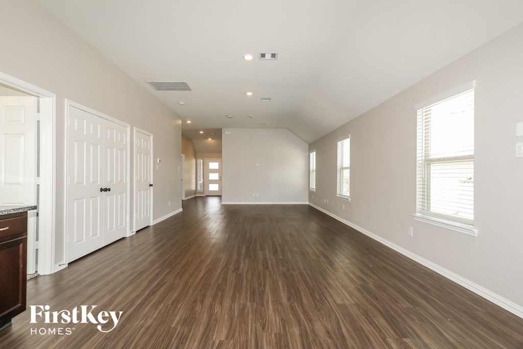 a living room with a hard wood floor and white walls
