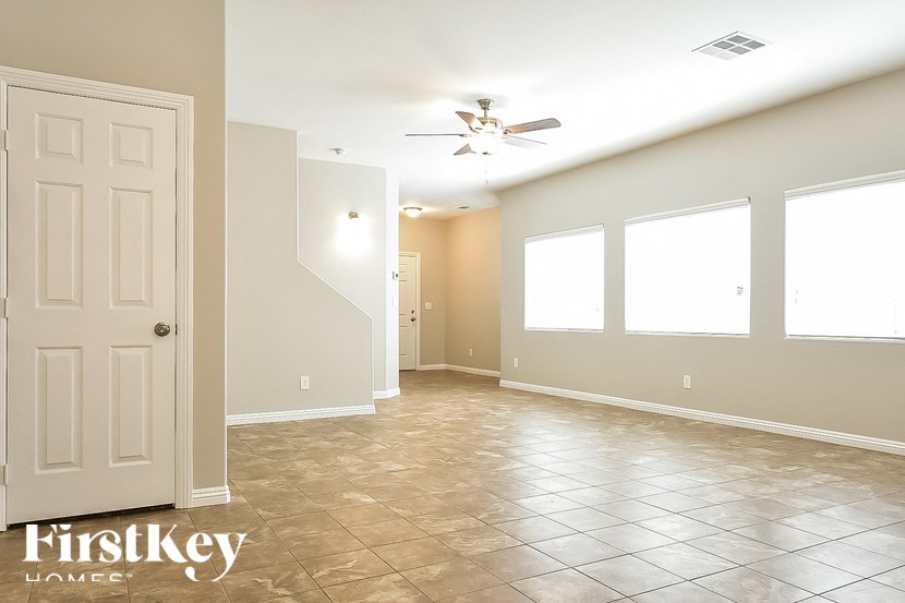 A spacious room with a tiled floor and a ceiling fan.