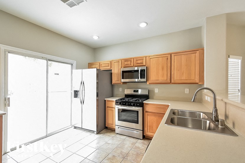 A kitchen with a white refrigerator, a microwave, a stove, and a sink.