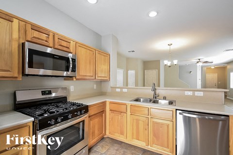 A kitchen with wooden cabinets and a stainless steel dishwasher.