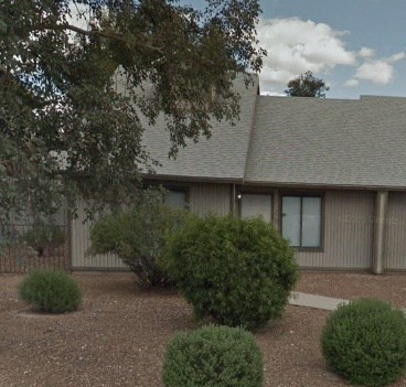 A building with a grey roof and a brown fence.