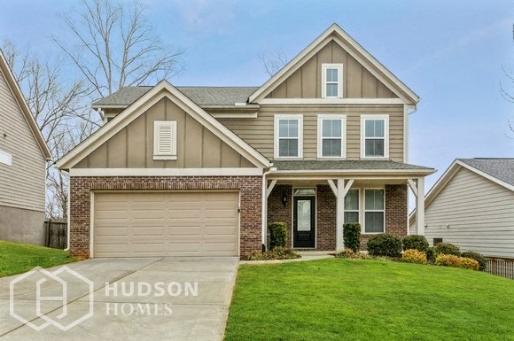 a home with a garage door and a lawn