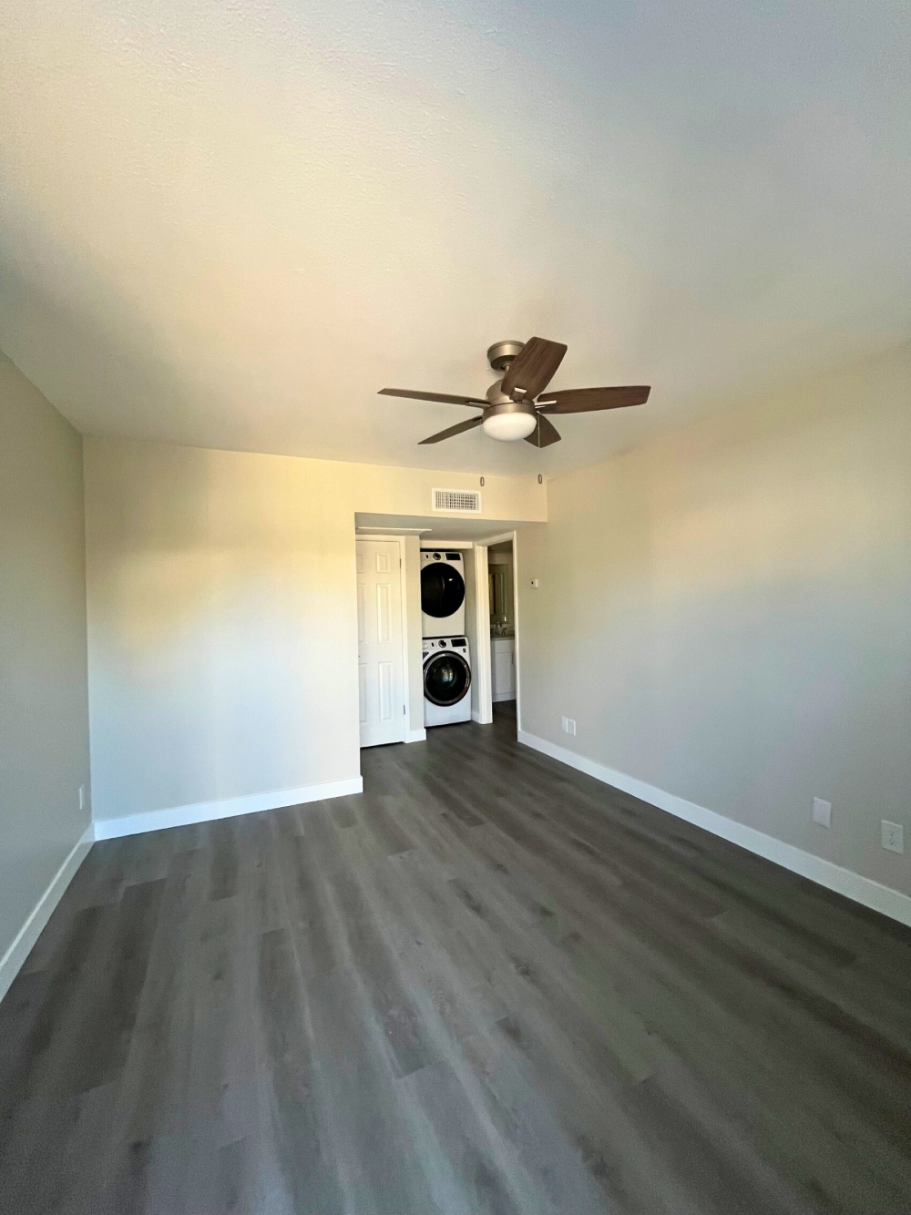 a living room with wood floors and a ceiling fan