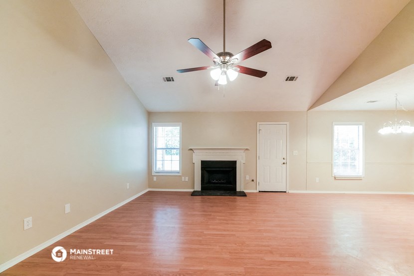the living room with fireplace and ceiling fan